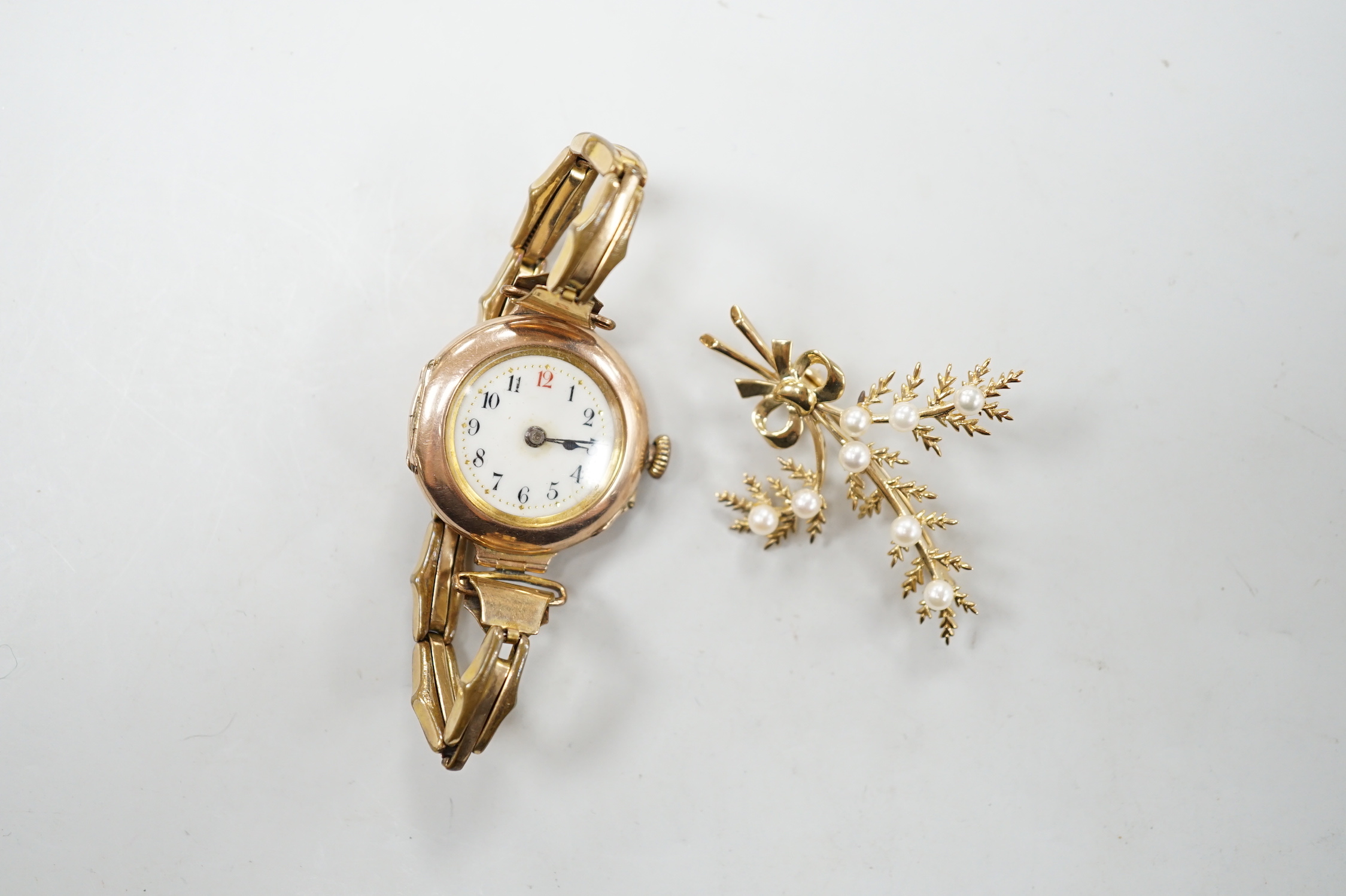 A lady's early 20th century 9ct gold, manual wind wrist watch, on a gold plated strap, together with a modern 9ct gold and seed pearl floral spray brooch.